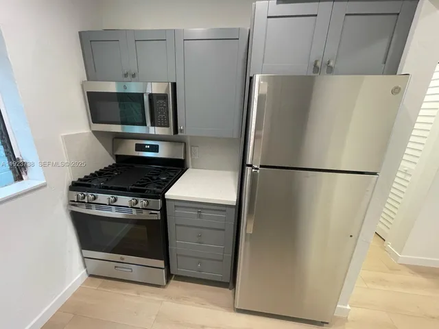 a kitchen with a refrigerator and a stove