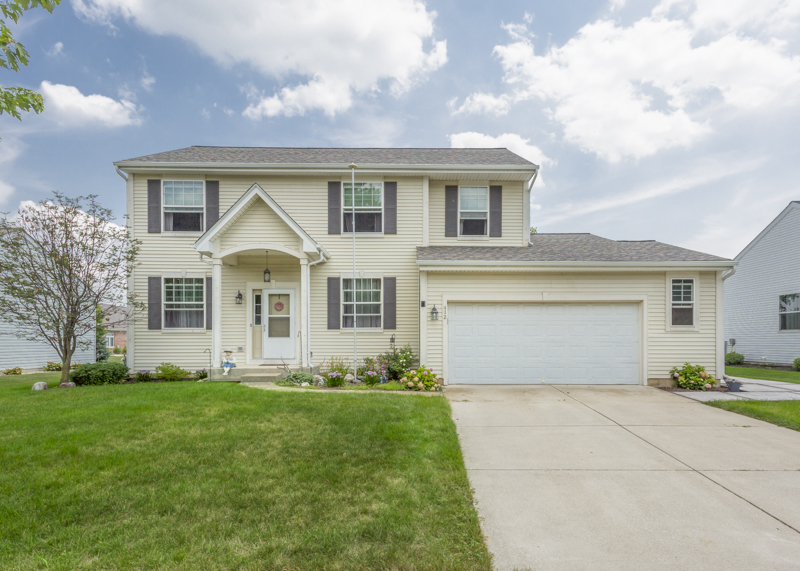 a front view of a house with a yard and garage