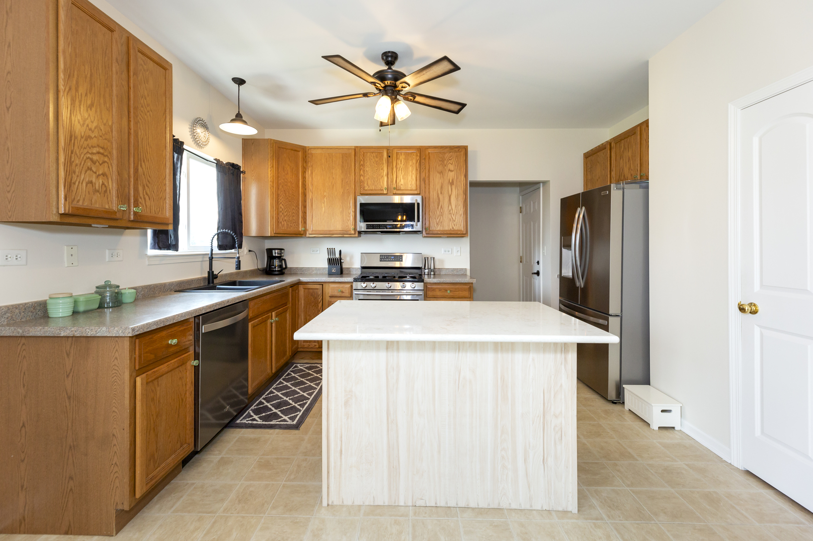 412 Preserve Drive Genoa, IL 60135 - Photo 17 of 39 a kitchen with stainless steel appliances a stove a refrigerator a sink a microwave oven with a dining table and chairs