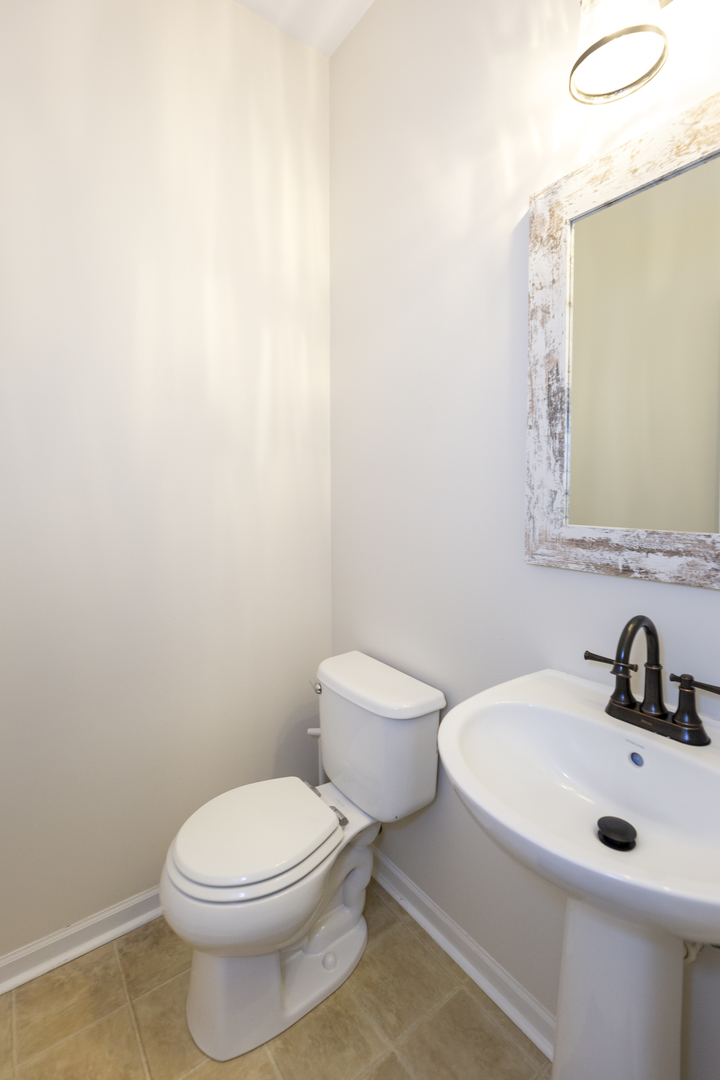412 Preserve Drive Genoa, IL 60135 - Photo 20 of 39 a white toilet sitting next to a bathroom sink