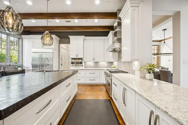 a large kitchen with stainless steel appliances granite countertop a lot of counter space and a large window