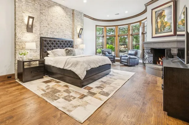 a bedroom with a bed wooden floor and a fireplace