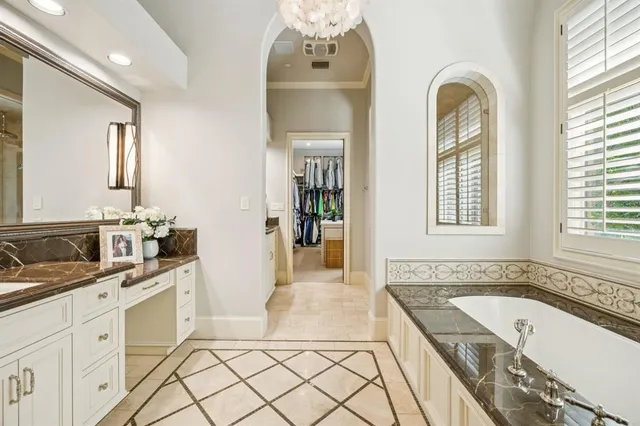 a spacious bathroom with a granite countertop tub mirror and double vanity