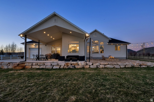 352 East Boulderville Road Oakley, UT 84055 - Photo 4 of 62 Back of property at dusk featuring a patio, stucco siding, and a garage