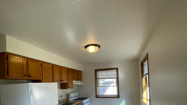 a kitchen with a refrigerator a stove top oven a sink and dishwasher with wooden floor