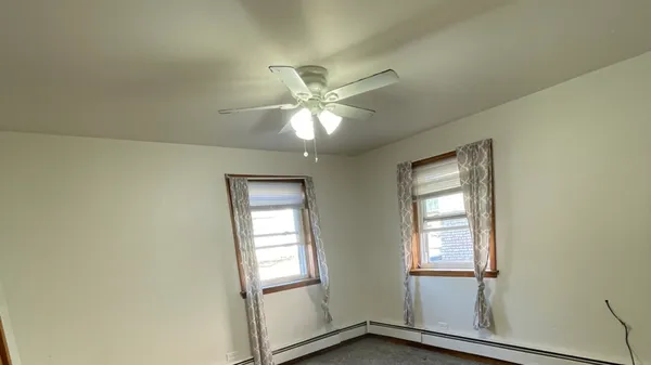 an empty room with windows and fan