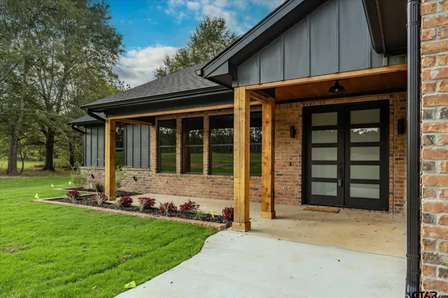 a front view of a house with a garden and yard
