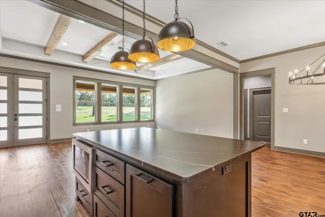 a kitchen with a table a stove and wooden floor