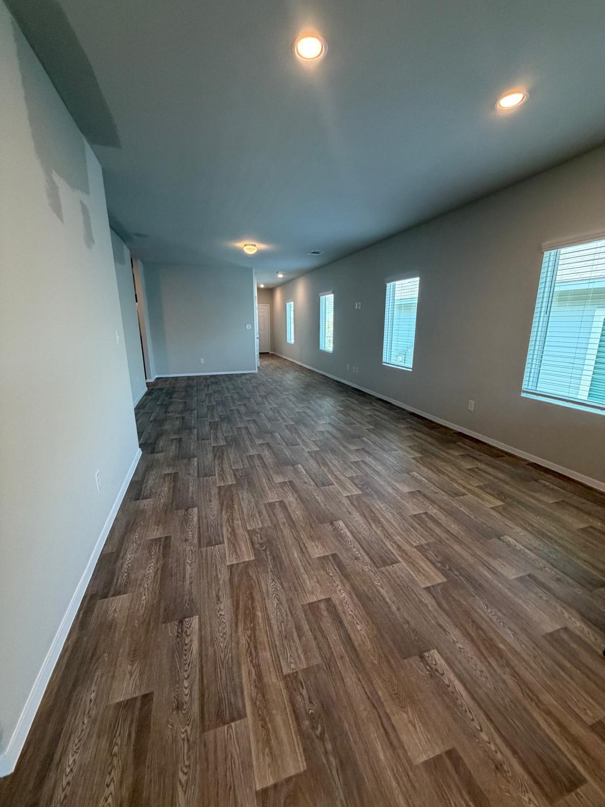 2701 Towy Road Manor, TX 78653 - Photo 10 of 35 Enjoy the inviting ambiance of this well-lit hallway with durable, low-maintenance wood-look flooring.