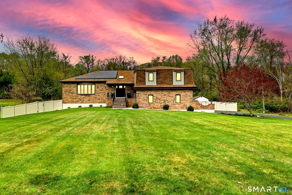 a front view of a house with a yard and trees