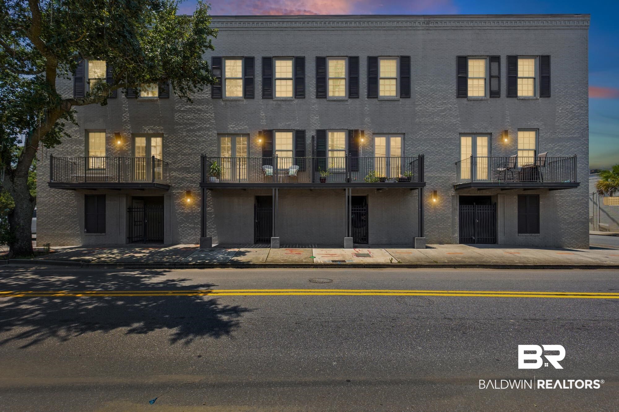 701 Dauphin Street, Unit A Mobile, AL 36602 - Photo 2 of 31 Three-story brick building facade with multiple balconies and individual entrances