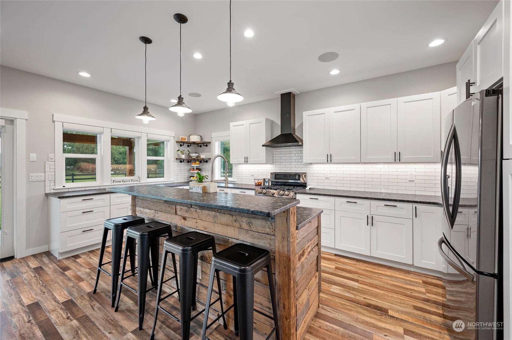 760 East Pole Road Lynden, WA 98264 - Photo 8 of 40 a kitchen with stainless steel appliances granite countertop wooden floor a stove a sink a refrigerator and chairs
