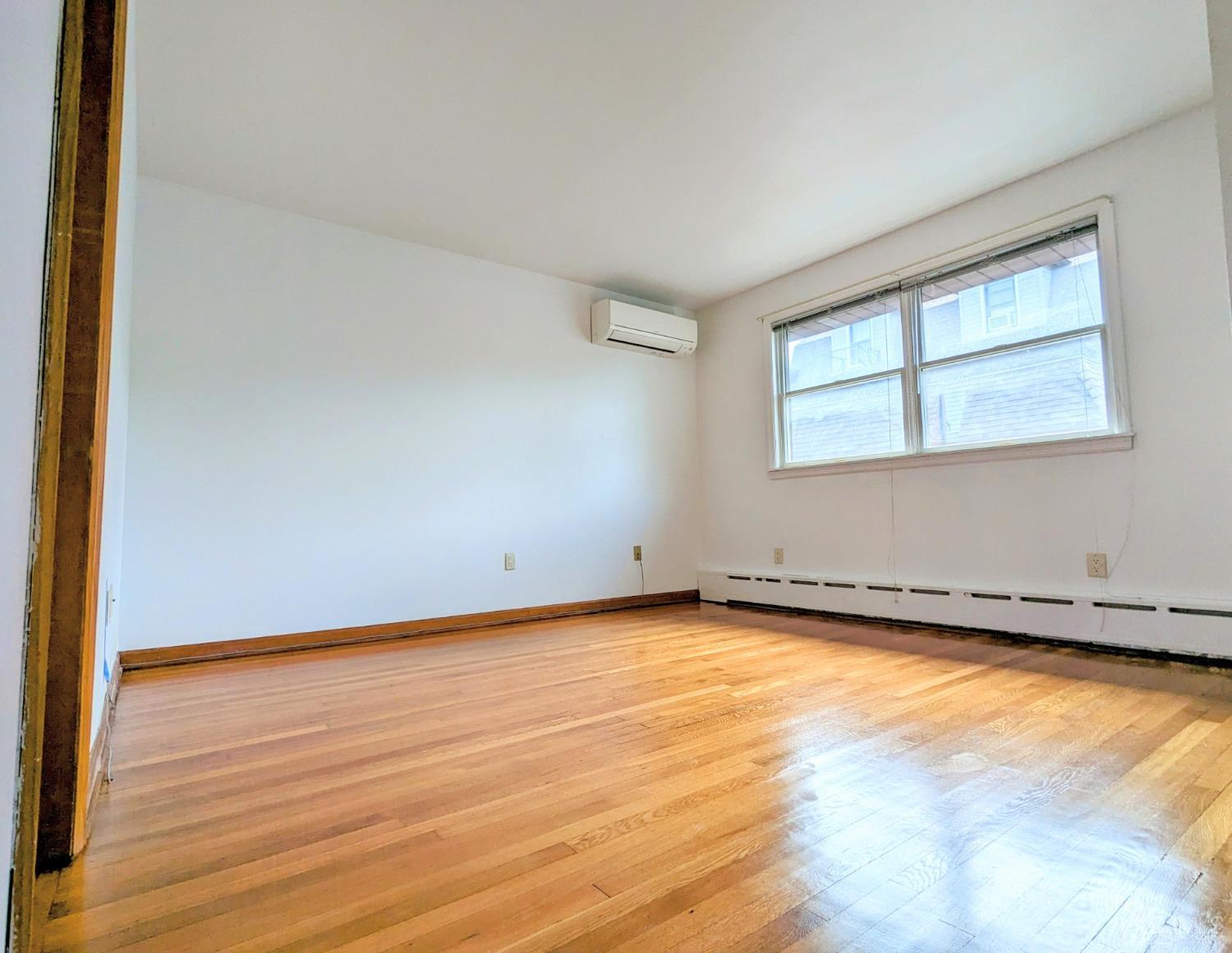 107 Madison Avenue, Unit 2 Dunellen, NJ 08812 - Photo 6 of 18 a view of a room with wooden floor and a window