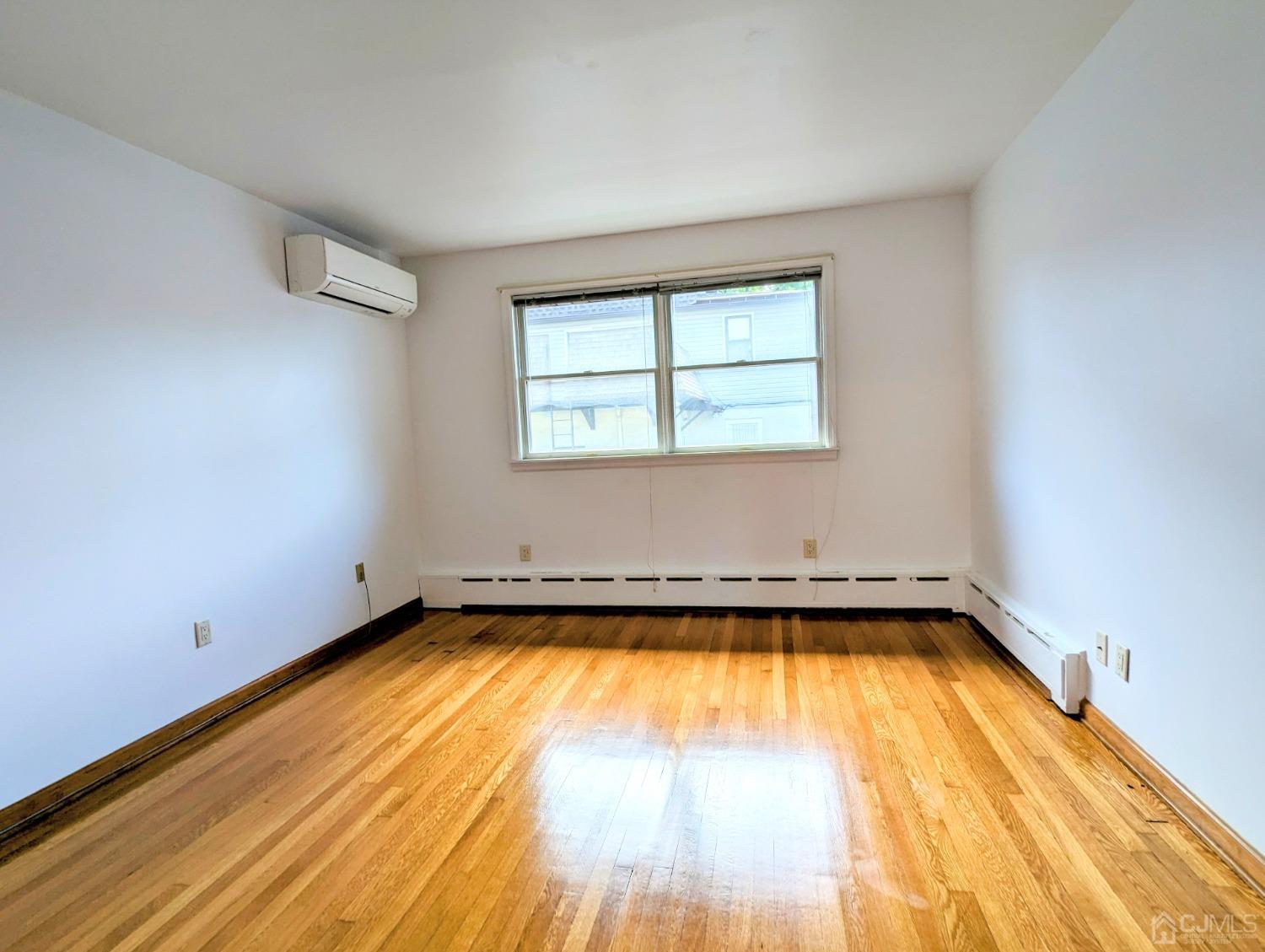 107 Madison Avenue, Unit 2 Dunellen, NJ 08812 - Photo 7 of 18 a view of a room with wooden floor and a window