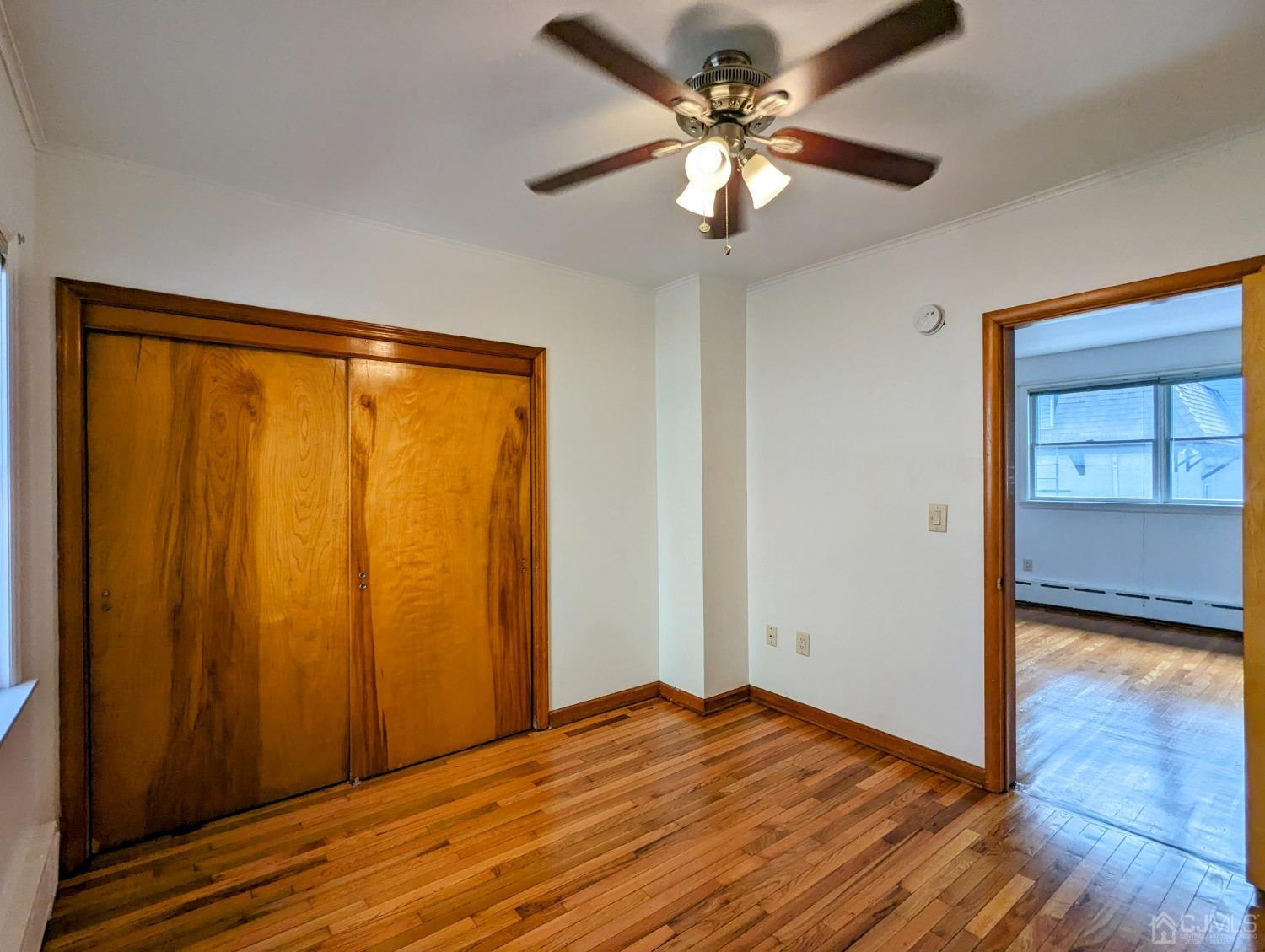 107 Madison Avenue, Unit 2 Dunellen, NJ 08812 - Photo 10 of 18 a view of empty room with wooden floor and fan