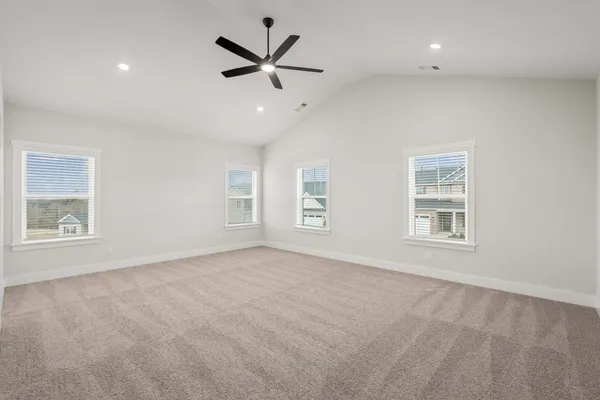 an empty room with windows and fan