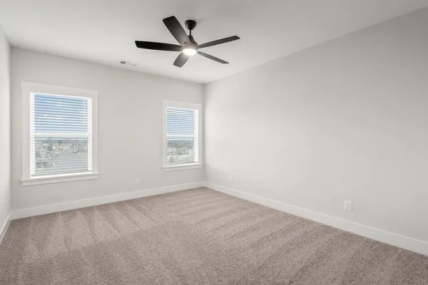 an empty room with a window and a ceiling fan