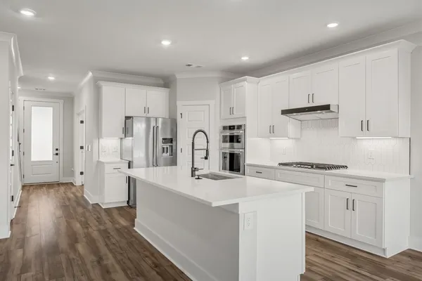 a kitchen with stainless steel appliances a refrigerator sink and cabinets