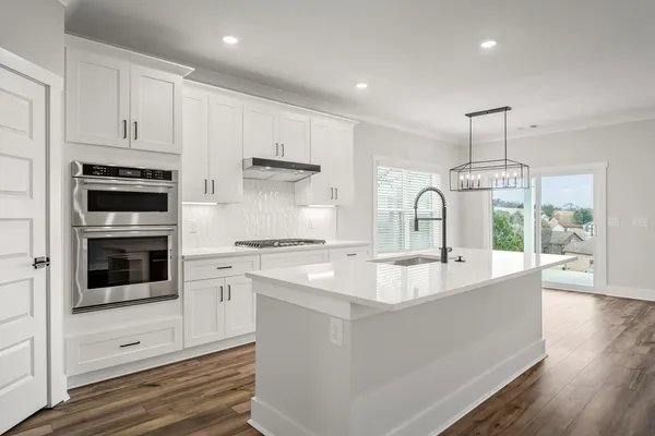 a large white kitchen has a stove and a sink