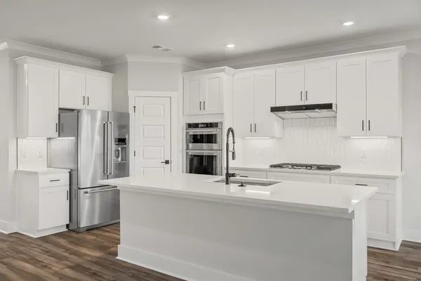 a kitchen with stainless steel appliances a refrigerator and a stove top oven