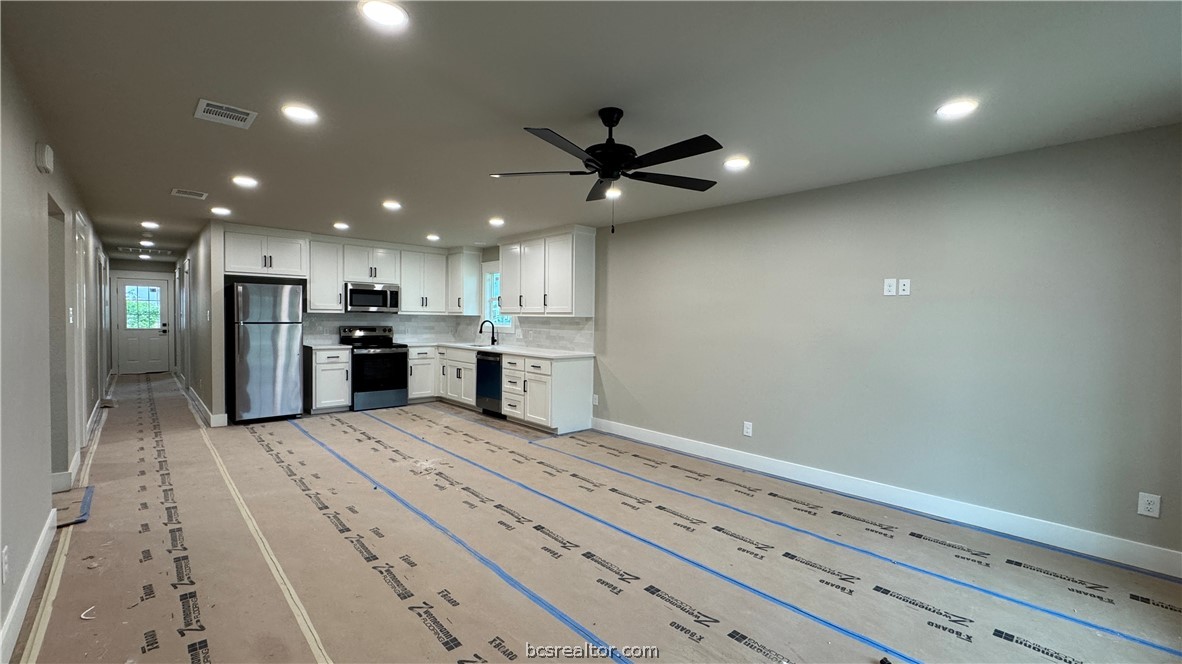 309 Wheelock Street Franklin, TX 77856 - Photo 4 of 15 a kitchen with stainless steel appliances kitchen island granite countertop a refrigerator and a sink