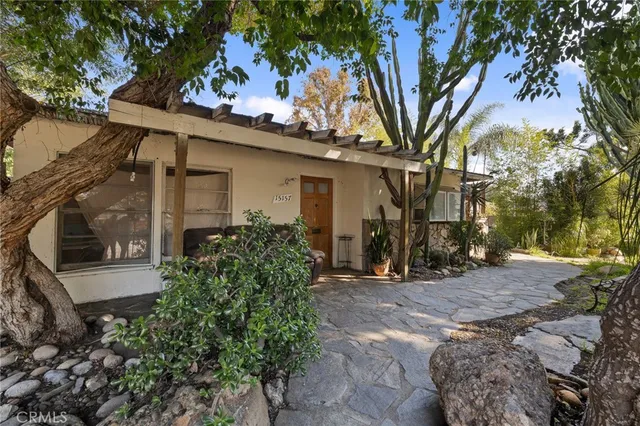 a front view of a house with a tree