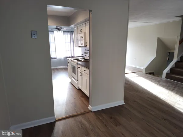 a kitchen with kitchen island granite countertop a stove and a wooden floor