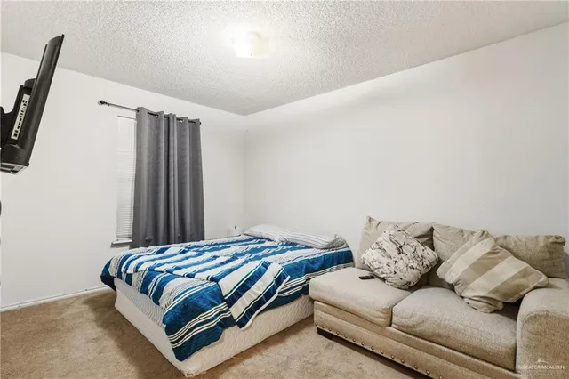 a bedroom with a bed couch and a window