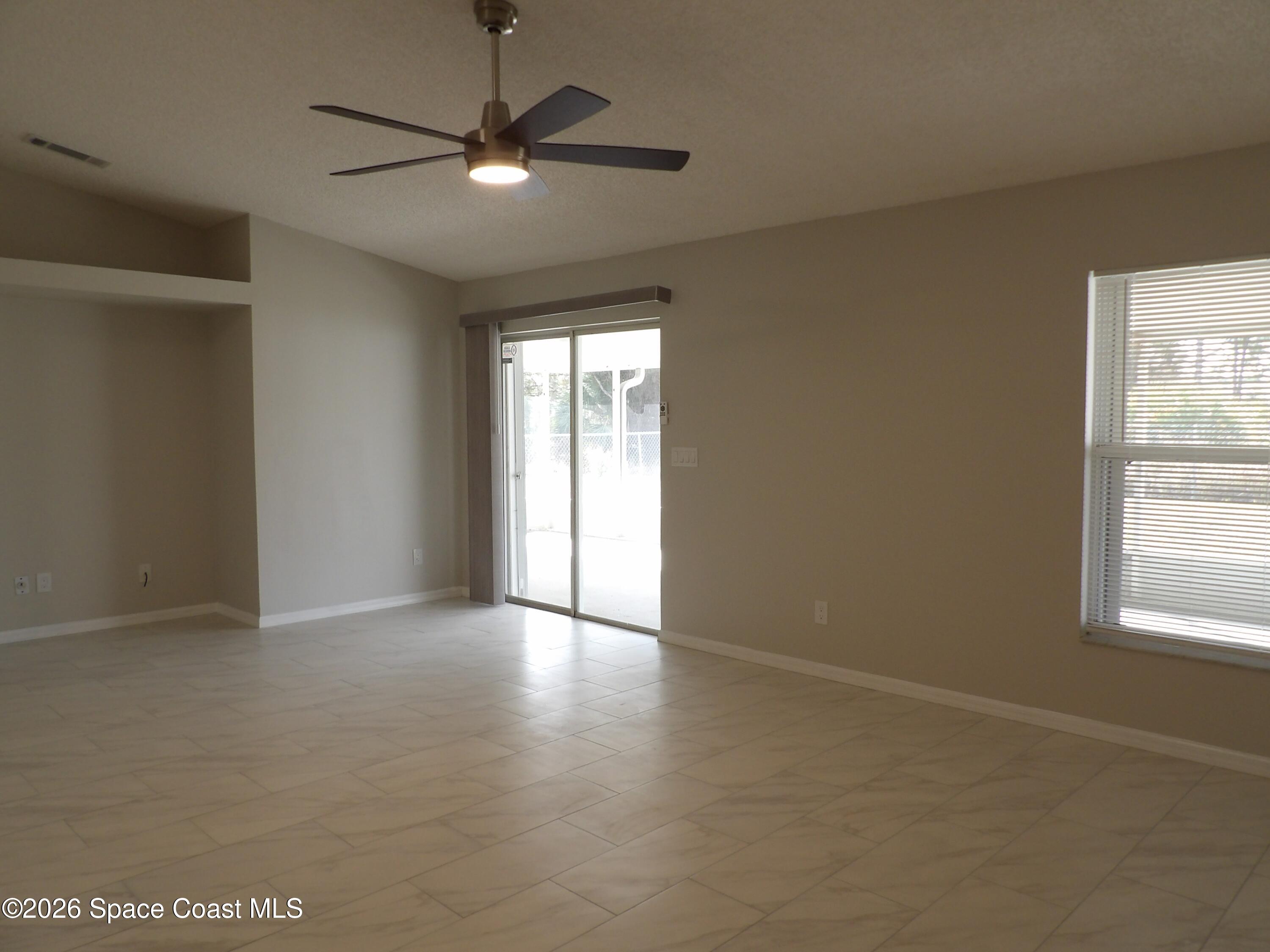 542 Octavius Road Southwest Palm Bay, FL 32908 - Photo 14 of 33 an empty room with window and a ceiling fan