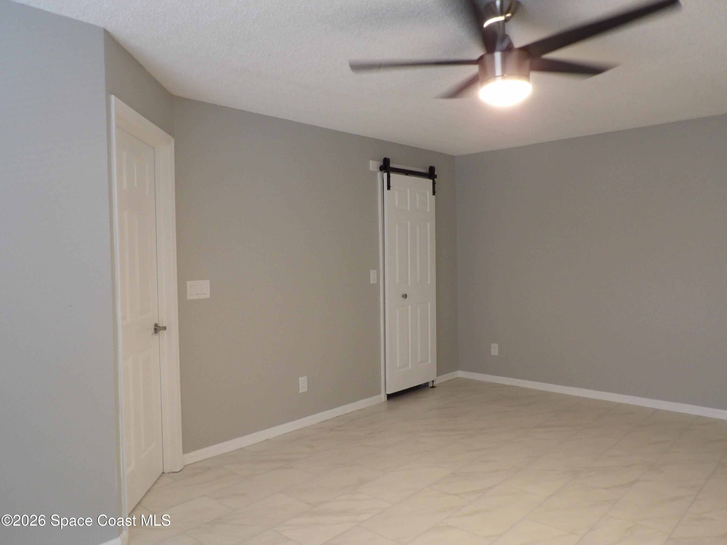 542 Octavius Road Southwest Palm Bay, FL 32908 - Photo 24 of 33 an empty room with a fan & a ceiling fan