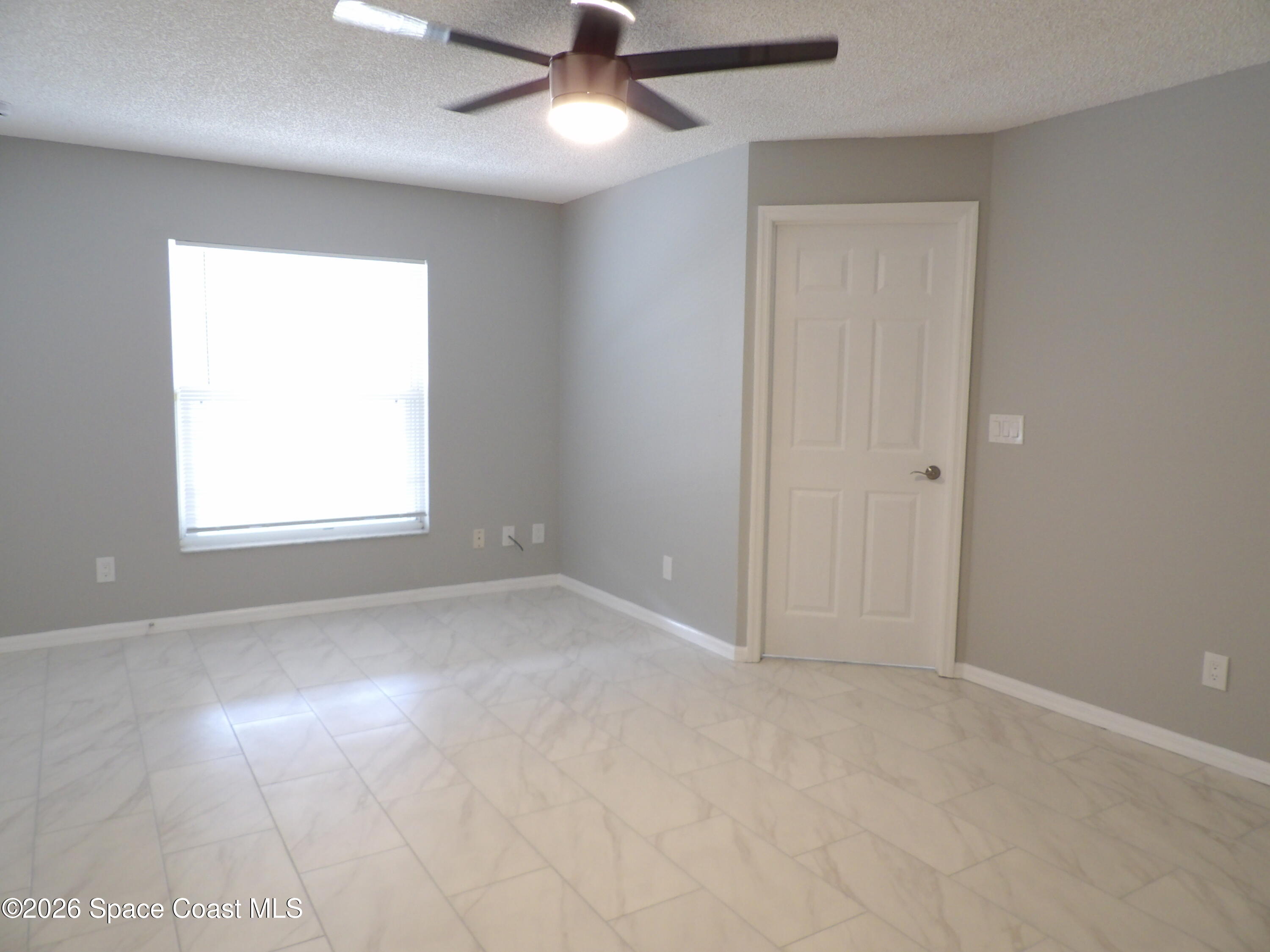 542 Octavius Road Southwest Palm Bay, FL 32908 - Photo 25 of 33 an empty room with windows and fan