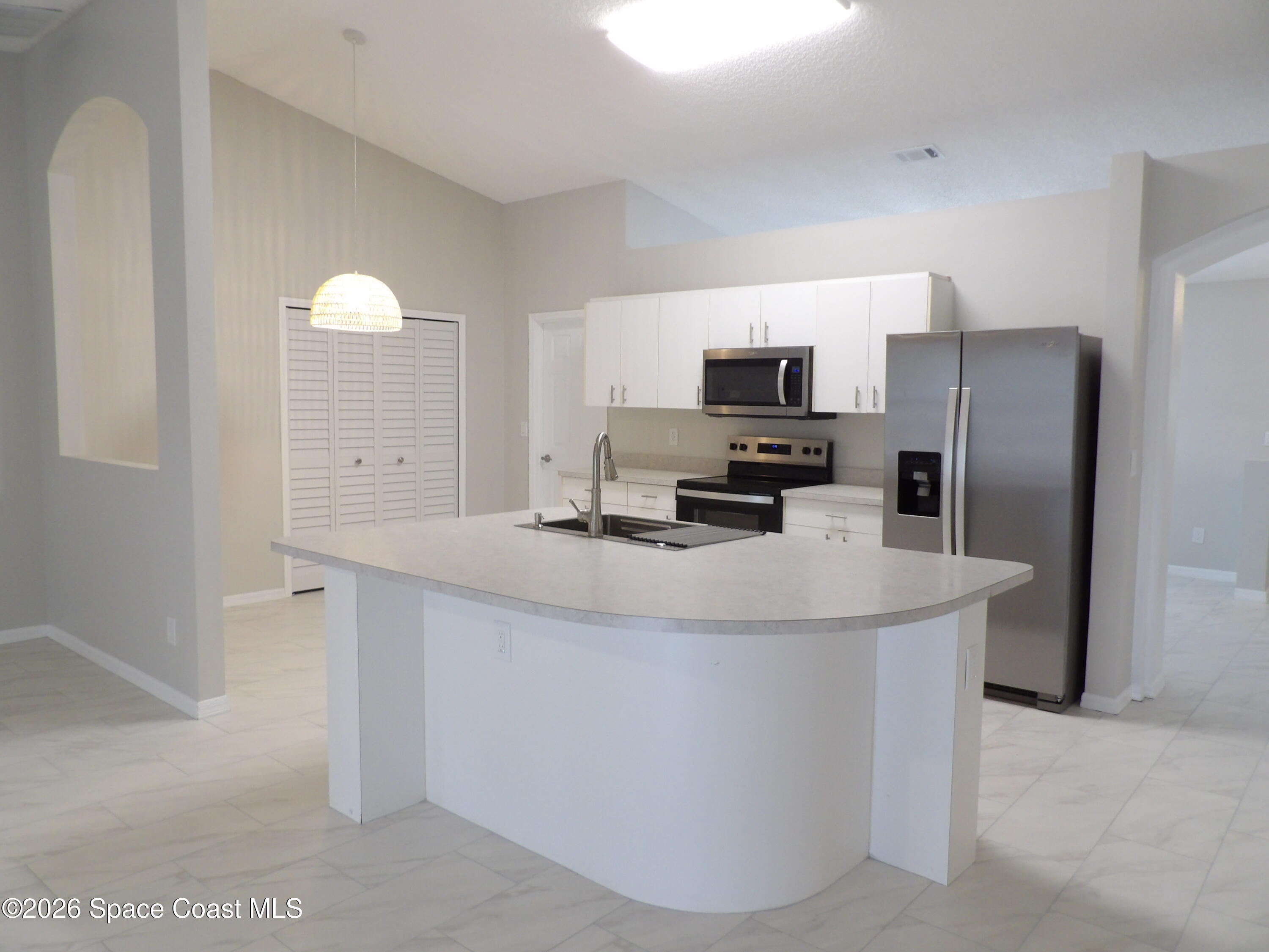 542 Octavius Road Southwest Palm Bay, FL 32908 - Photo 8 of 33 a kitchen with stainless steel appliances a refrigerator sink and stove
