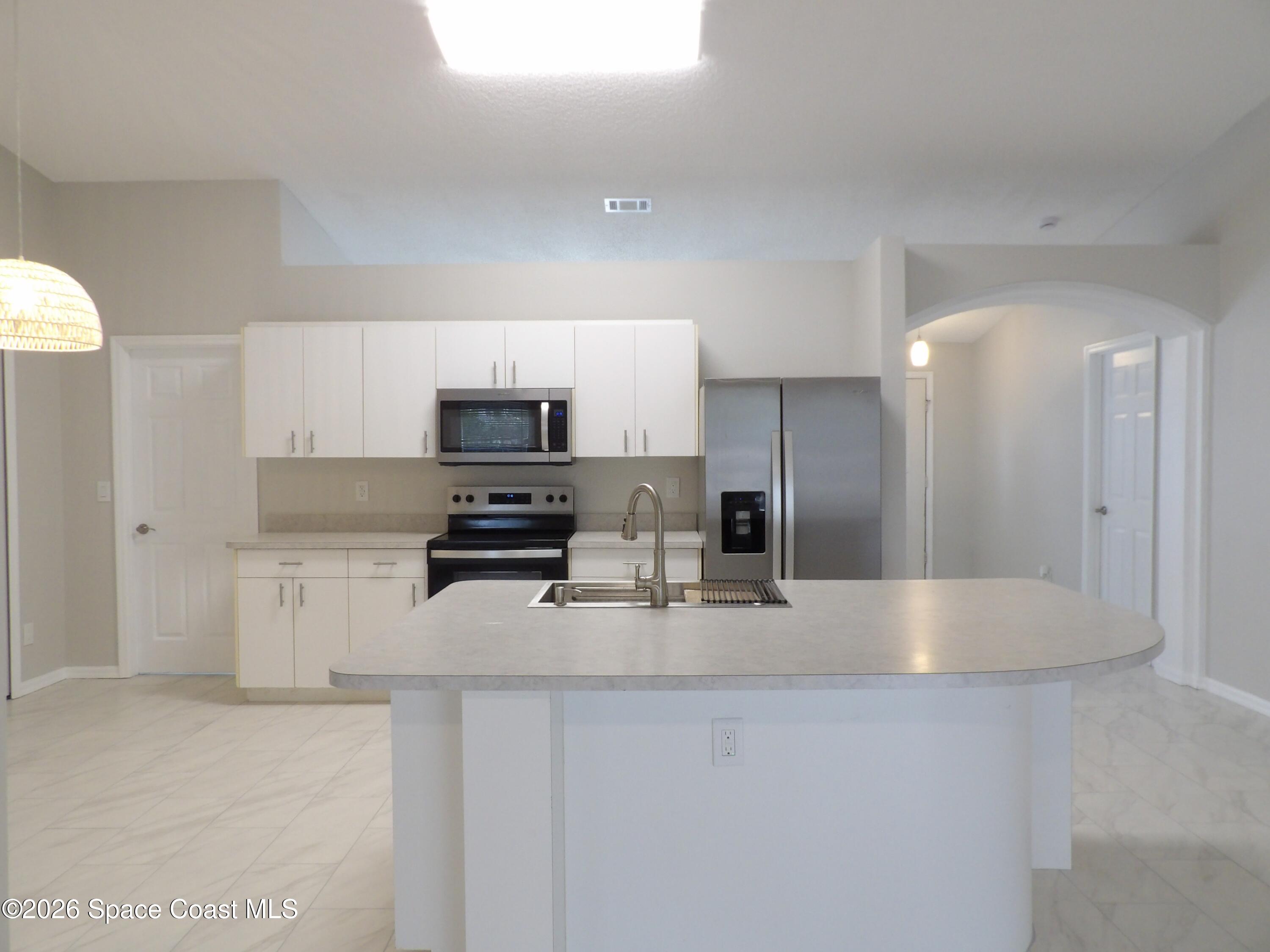 542 Octavius Road Southwest Palm Bay, FL 32908 - Photo 9 of 33 a kitchen with stainless steel appliances granite countertop a refrigerator a stove a sink and a white cabinets
