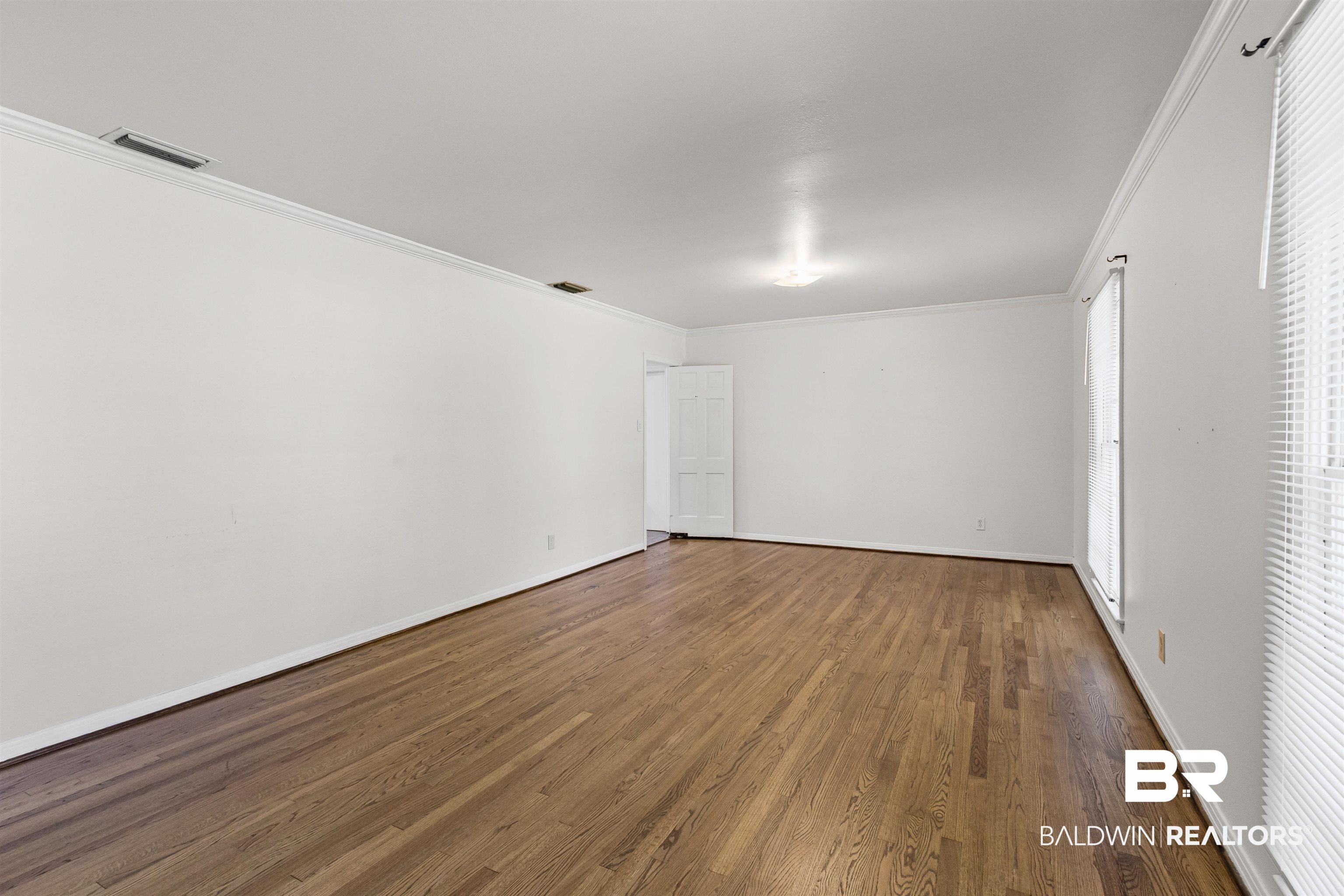 1108 Locarno Street Mobile, AL 36608 - Photo 12 of 24 Spare room featuring crown molding and wood finished floors