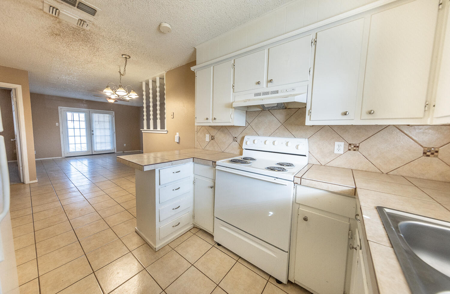 5308 23rd Street Lubbock, TX 79407 - Photo 11 of 25 a kitchen with granite countertop white cabinets and white appliances