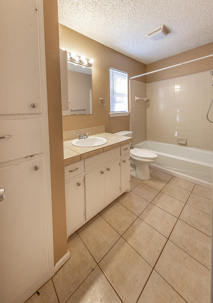 5308 23rd Street Lubbock, TX 79407 - Photo 14 of 25 a bathroom with a granite countertop sink a toilet and a mirror