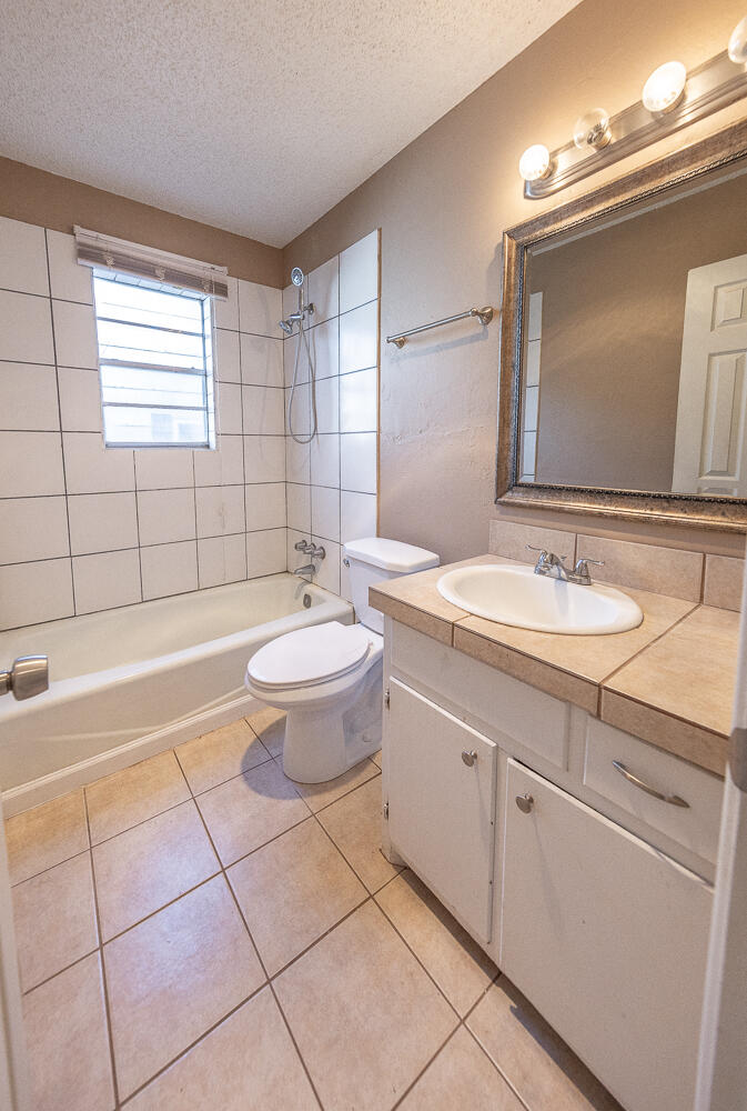 5308 23rd Street Lubbock, TX 79407 - Photo 17 of 25 a spacious bathroom with a granite countertop sink a toilet and a mirror