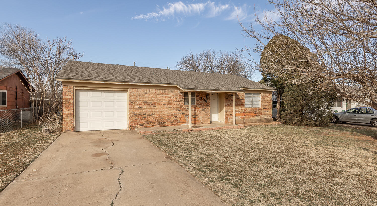 5308 23rd Street Lubbock, TX 79407 - Photo 2 of 25 a front view of a house with a yard and garage