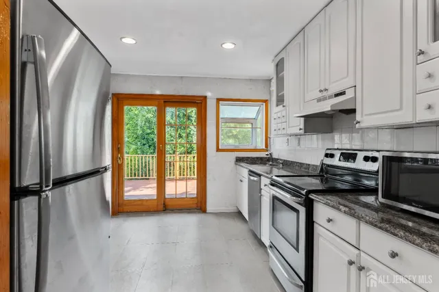 a kitchen with stainless steel appliances granite countertop a stove a refrigerator and a sink