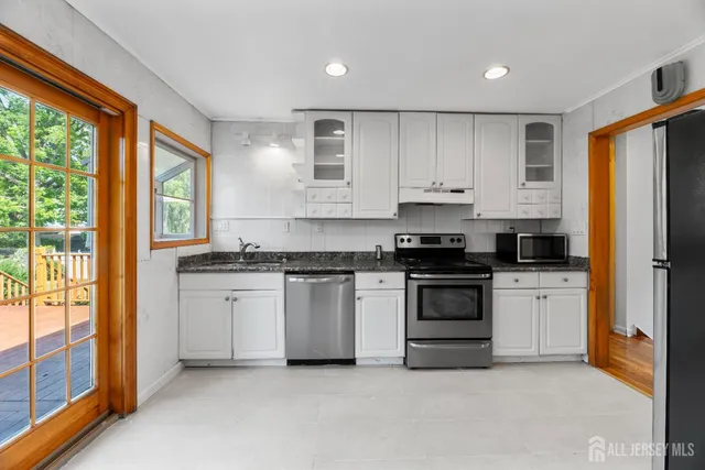 a kitchen with granite countertop white cabinets and white appliances