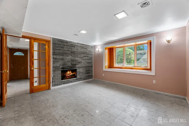 an empty room with windows and fireplace