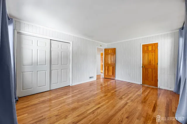 a view of an empty room with closet and a window