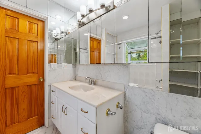 a bathroom with a sink a vanity a mirror and a shower