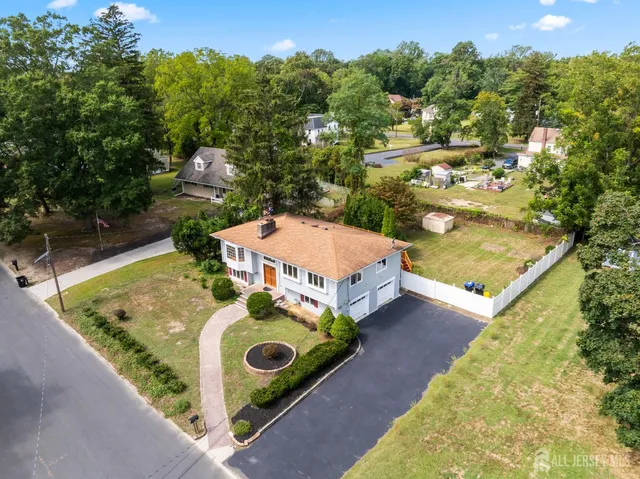an aerial view of a house with swimming pool and trees