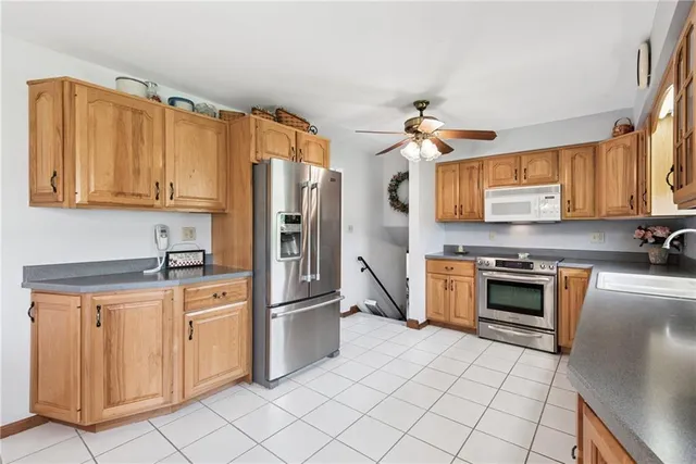 a kitchen with stainless steel appliances granite countertop a stove top oven a refrigerator and a sink