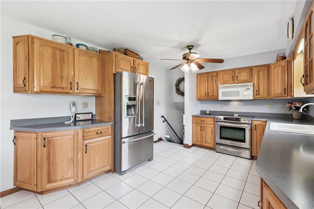 207 State Park Road New Alexandria, PA 15670 - Photo 11 of 38 a kitchen with stainless steel appliances granite countertop a stove top oven a refrigerator and a sink