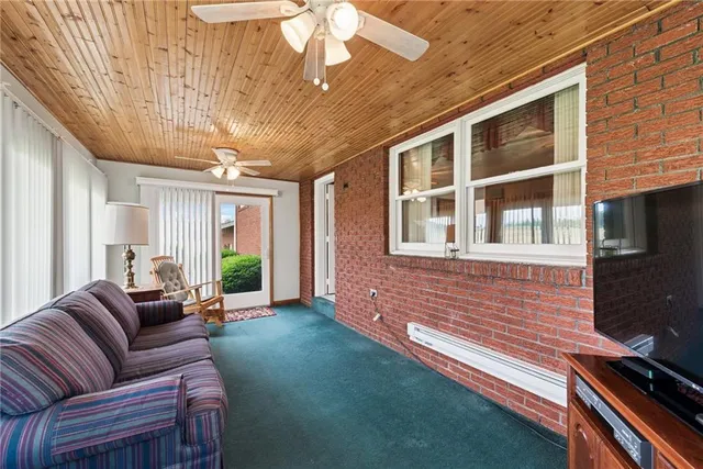 a living room with furniture and a ceiling fan