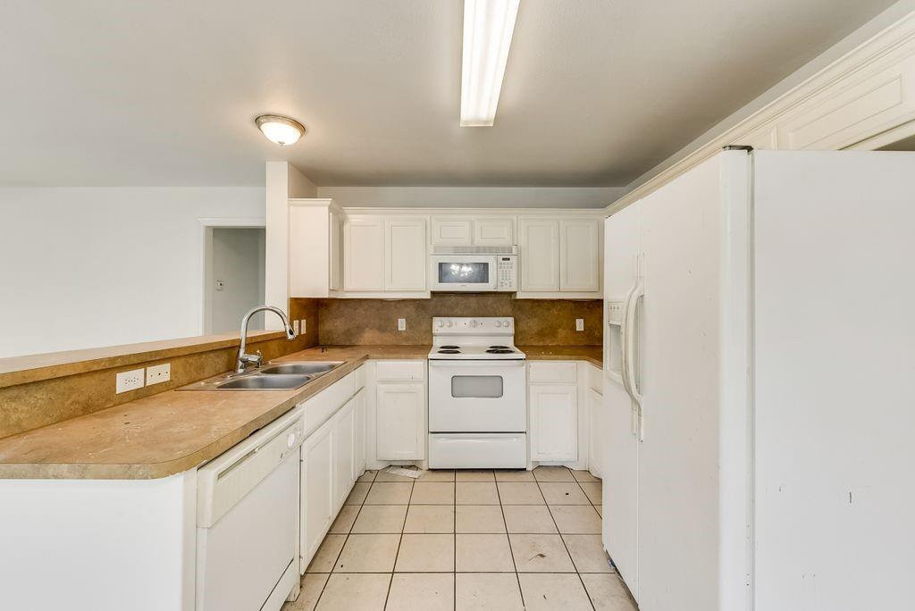 919 Farmington Road, Unit 919 Howe, TX 75459 - Photo 6 of 14 a kitchen with a stove a sink and a refrigerator