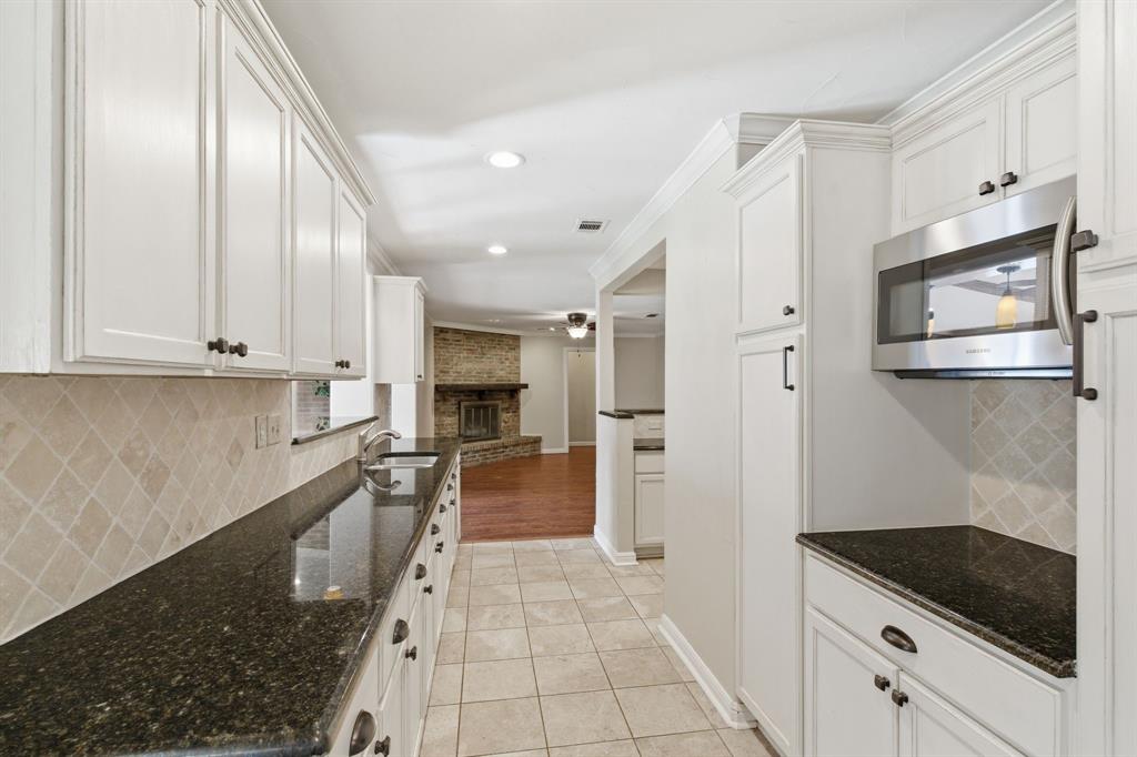 1760 Acorn Lane Hurst, TX 76054 - Photo 12 of 36 a kitchen with granite countertop white cabinets and stainless steel appliances