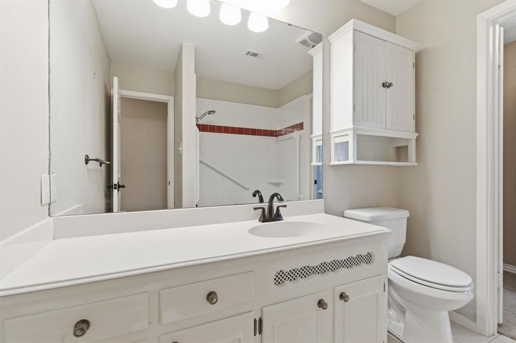1760 Acorn Lane Hurst, TX 76054 - Photo 24 of 36 a bathroom with a sink a toilet and a mirror